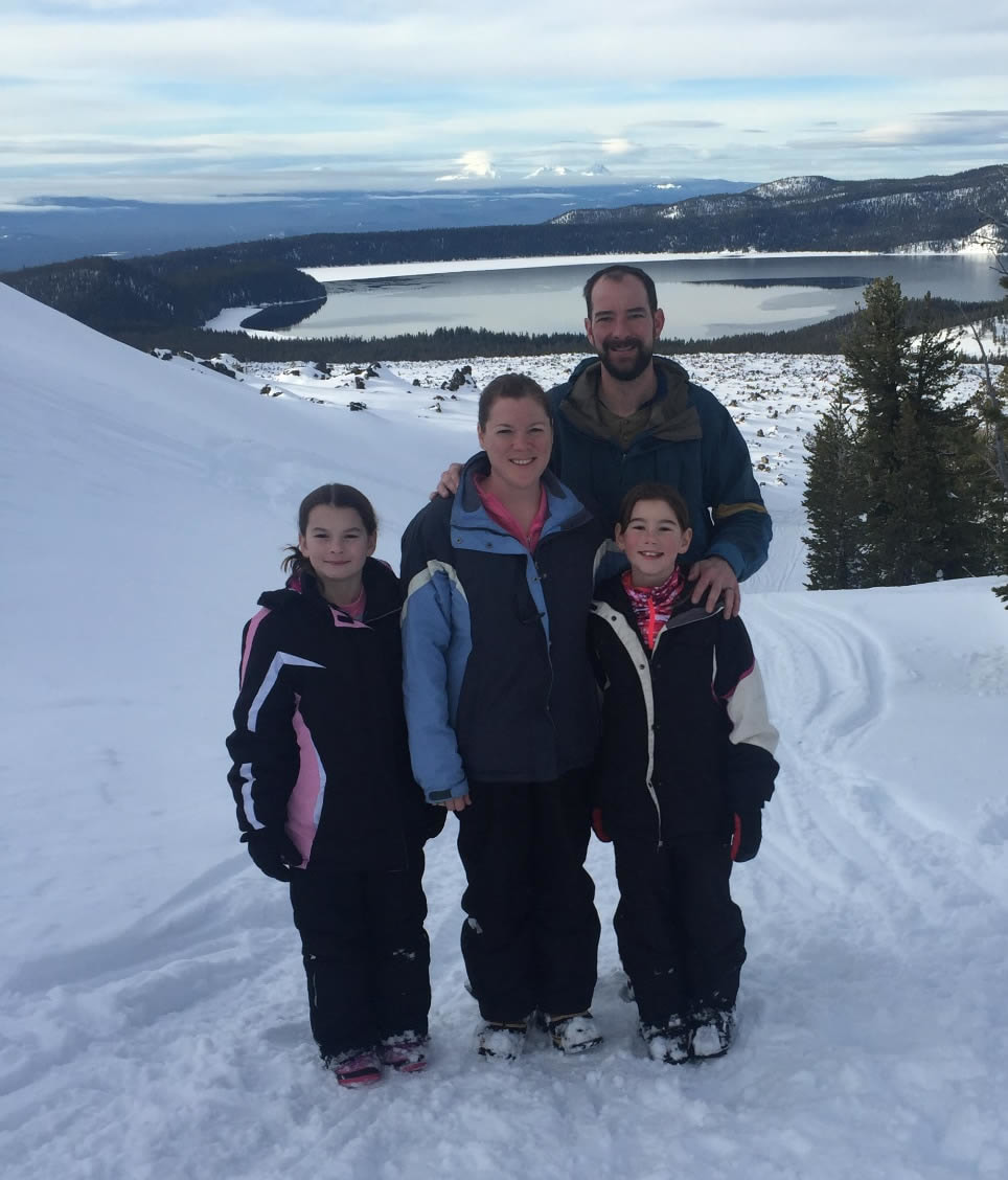 Mike's wife and two daughters on a snowy hill